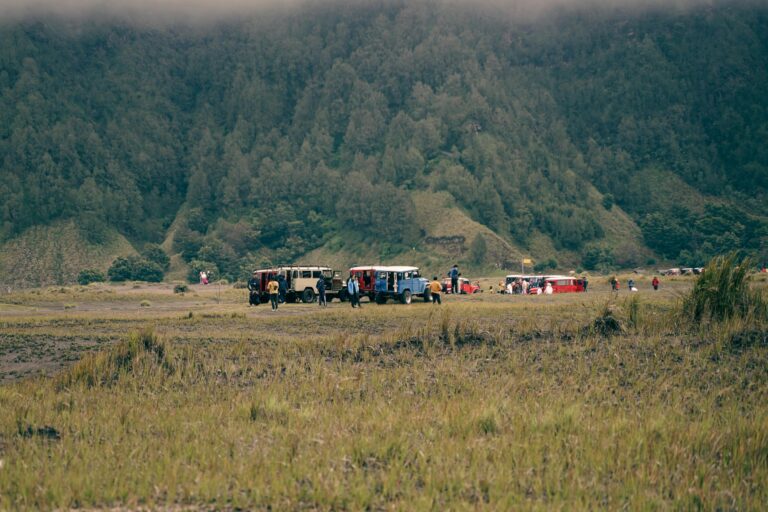 Jeeps parked in a lush valley, surrounded by mountains in Malang, East Java.