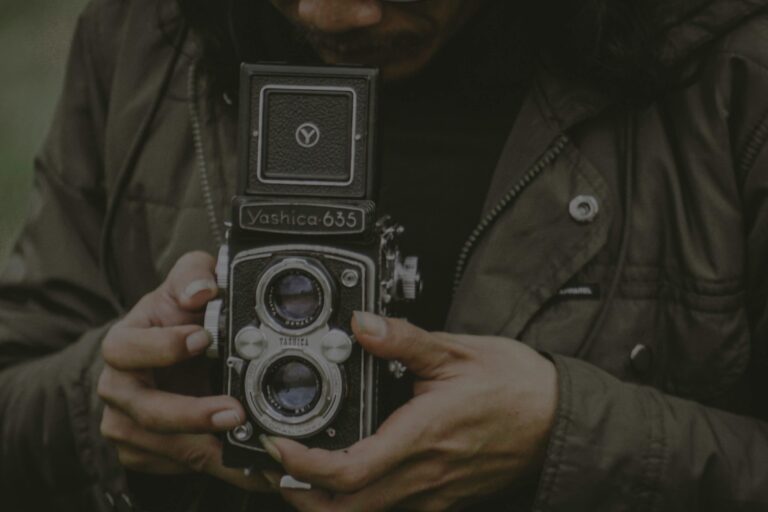 Close-up of hands holding a vintage Yashica 635 camera in Malang, Indonesia.